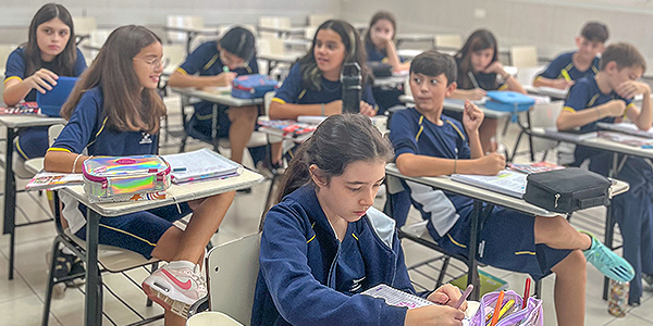 Alunos sentados em sala de aula estudando inglês.