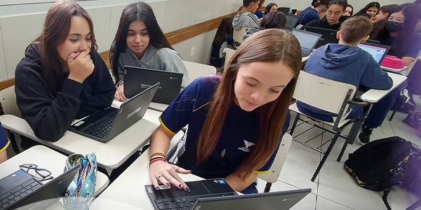 Alunos mexem no computador na Disciplina Pensamento Computacional do Colégio Londrinense. 