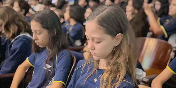 Aluna com a cabeça encostada na parede demonstrando estress. 