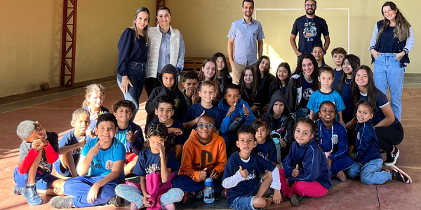 Turma de alunos sentados no chão no Colégio Londrinense que trabalha as inteligências múltiplas.