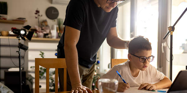 Pai ao lado do filho, que está estudando, apoio e incentivo